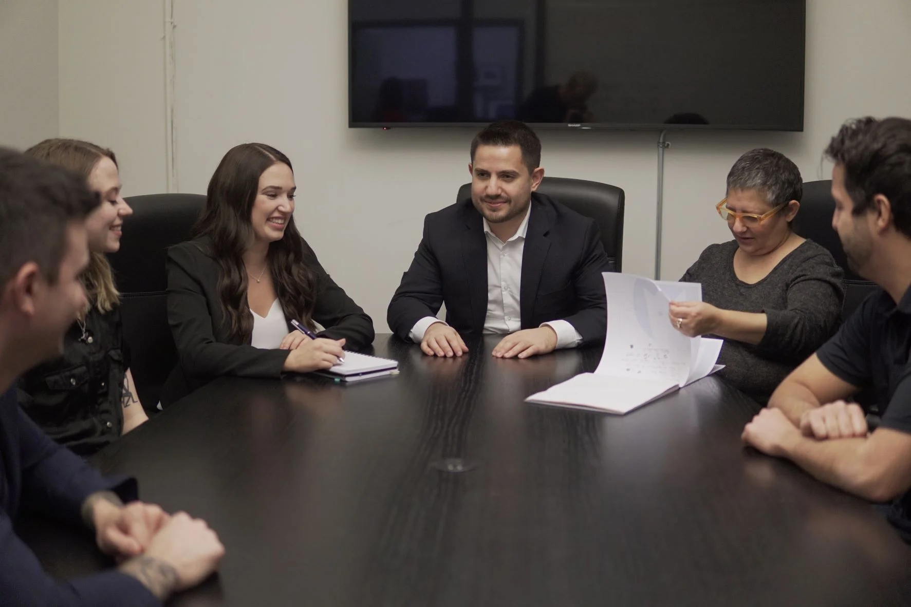 team sitting at the board table discussing work