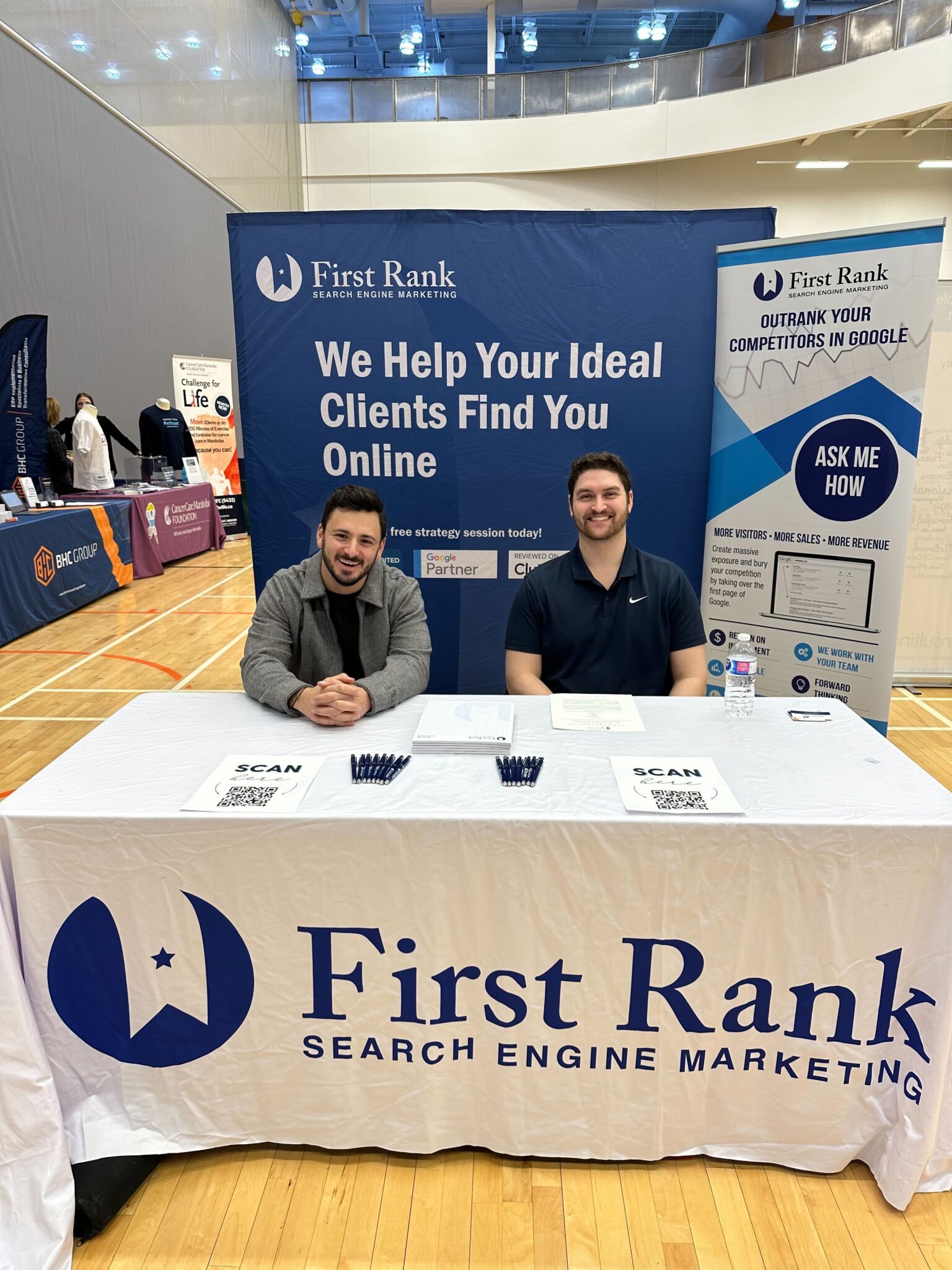 two men sitting at booth at tradeshow