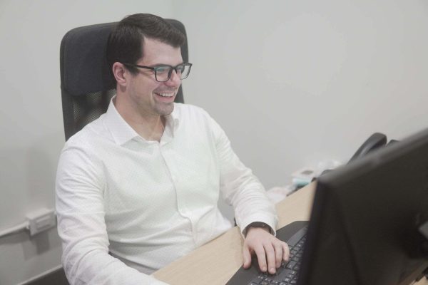 man sitting at desk working on a computer