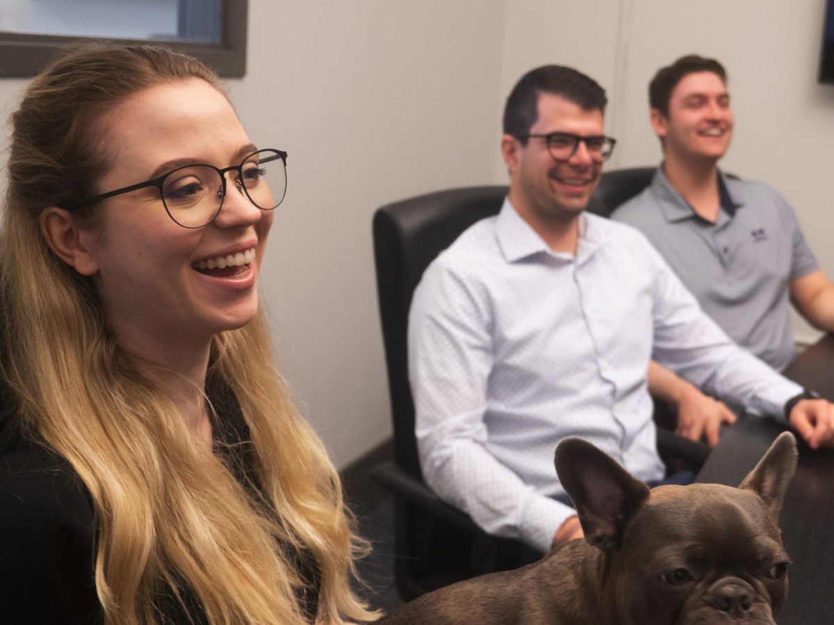 three members laughing while working on a project